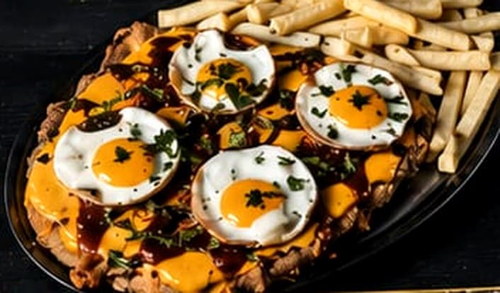 Milanesa a caballo con cheddar y papas
